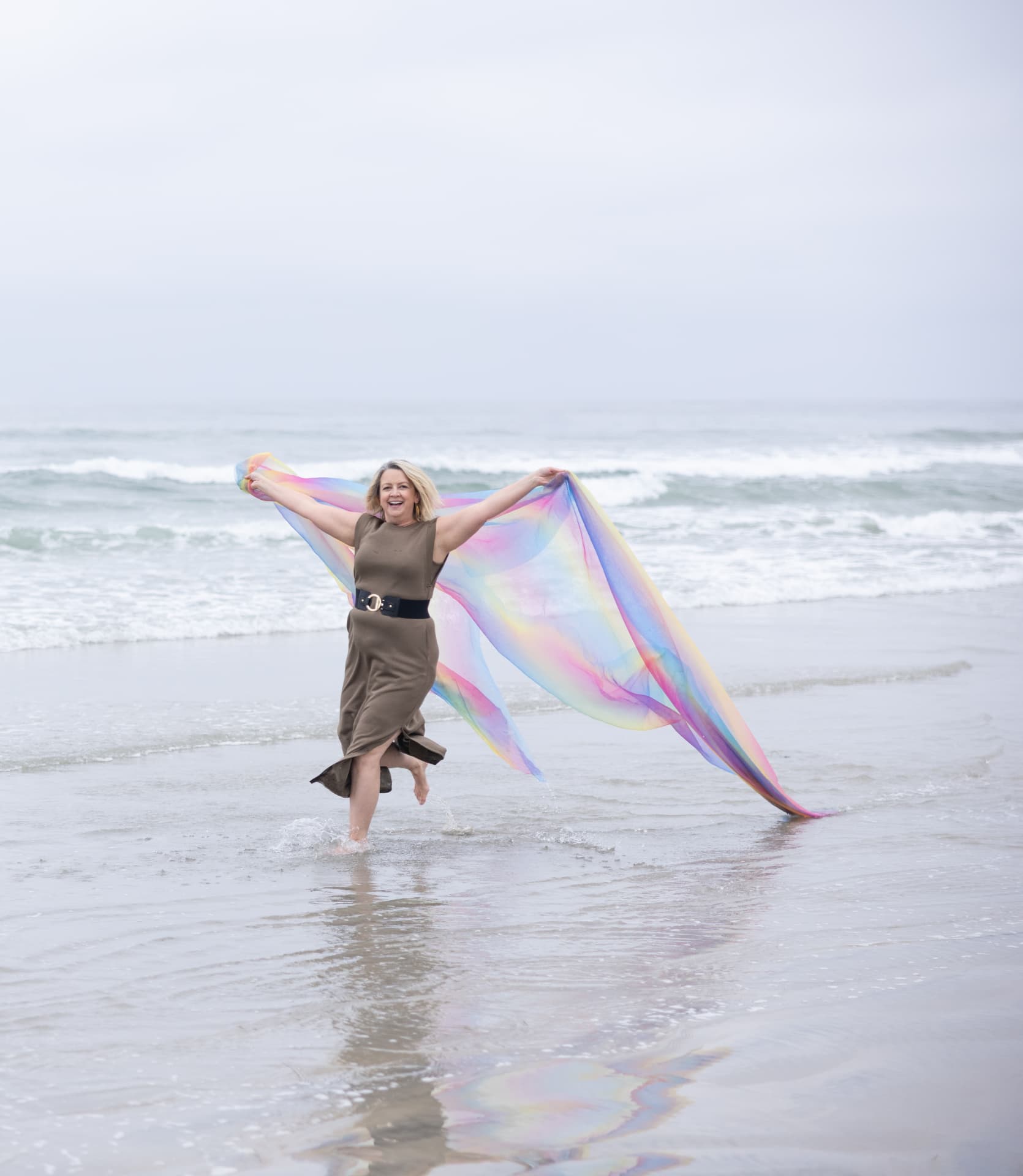 D. LeD running along the shoreline with a flowing rainbow scarf